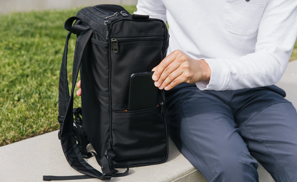 Person placing their phone in a smaller side pocket of the Cambiata.